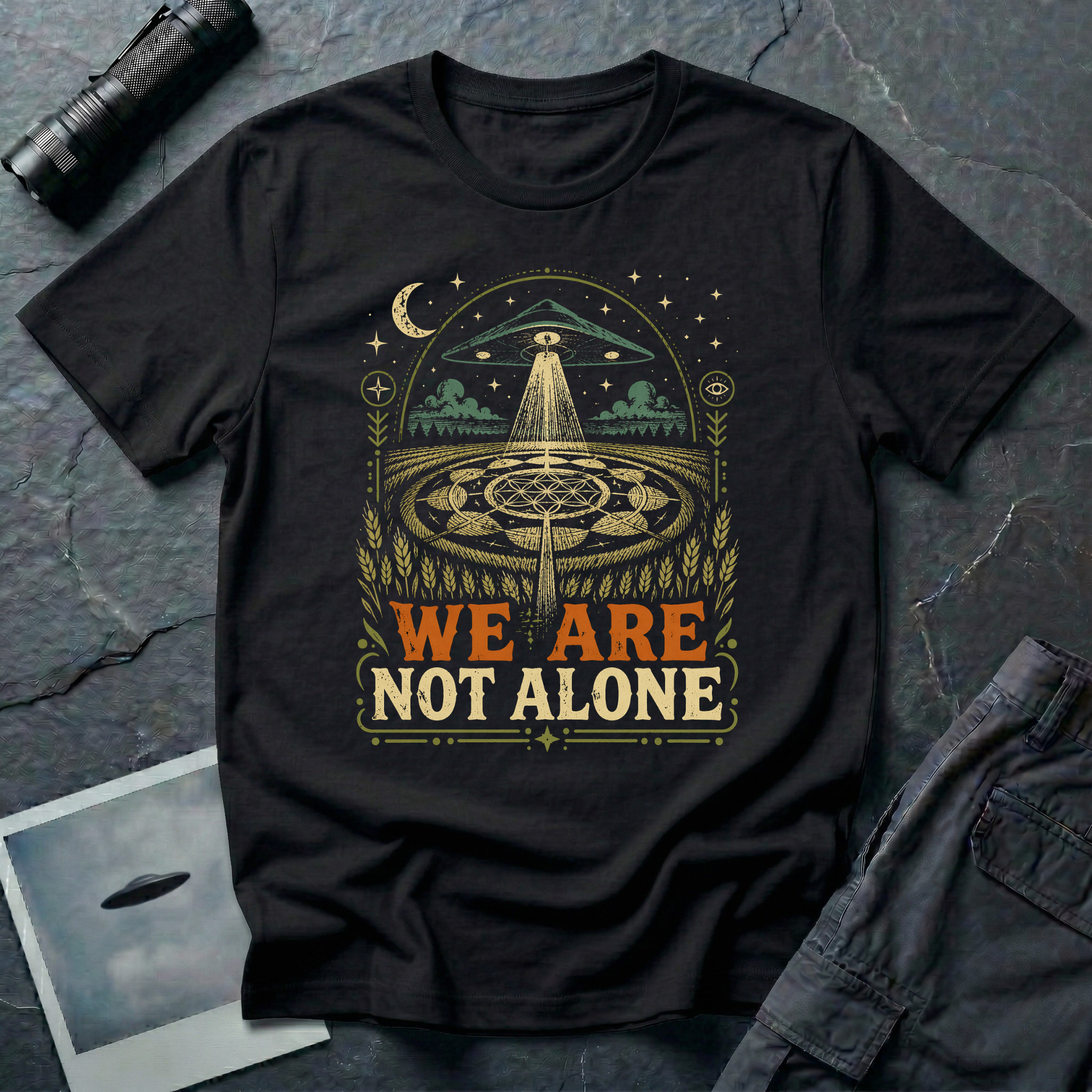 We Are Not Alone vintage UFO t-shirt — flying saucer over intricate crop circle and Flower of Life on black unisex cotton tee