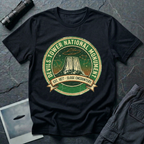 Devils Tower UFO t-shirt — vintage distressed National Park badge with the Wyoming monument silhouette, tiny flying saucers and constellations over a starry green sky, "DEVILS TOWER NATIONAL MONUMENT" arc text and "EST. 1906 — CLOSE ENCOUNTERS" banner on black cotton tee