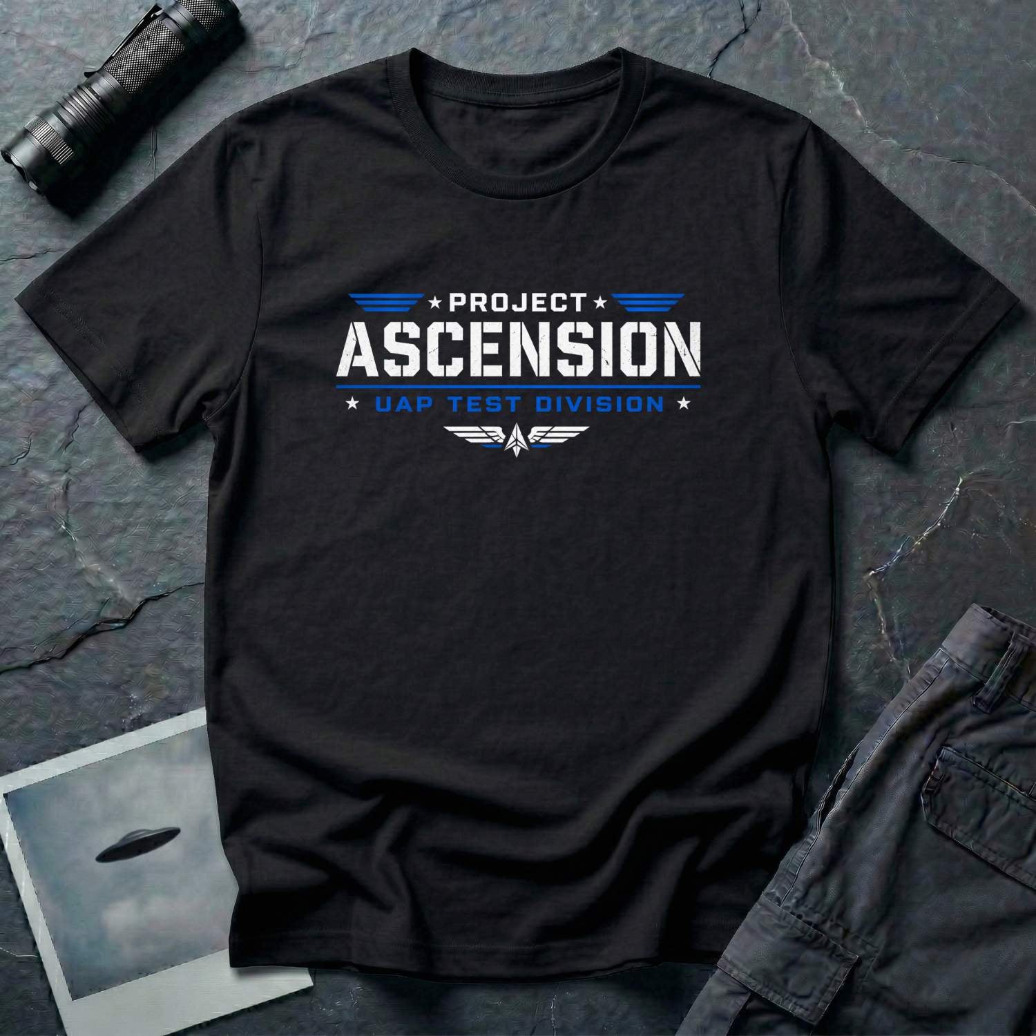 Black t-shirt with PROJECT ASCENSION UAP TEST DIVISION military stencil lettering in white and blue with winged delta emblem