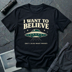 I Want To Believe ironic UFO t-shirt — classic teal saucer with the phrase "I want to believe (but I also want proof)" on black cotton tee