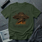 The Wicker Visit folk horror UFO t-shirt — woven wicker flying saucer with antler crown burning in orange flames on military green tee