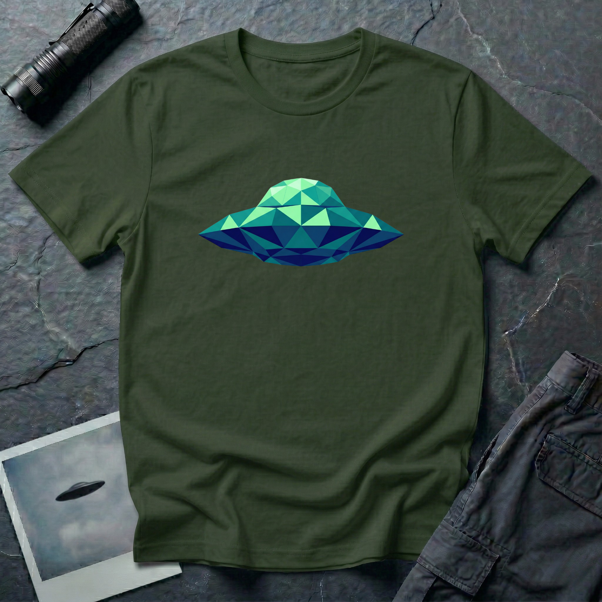 Cubist UFO geometric low poly t-shirt — classic flying saucer rendered in triangular facets of mint green, teal, and navy blue on green cotton tee