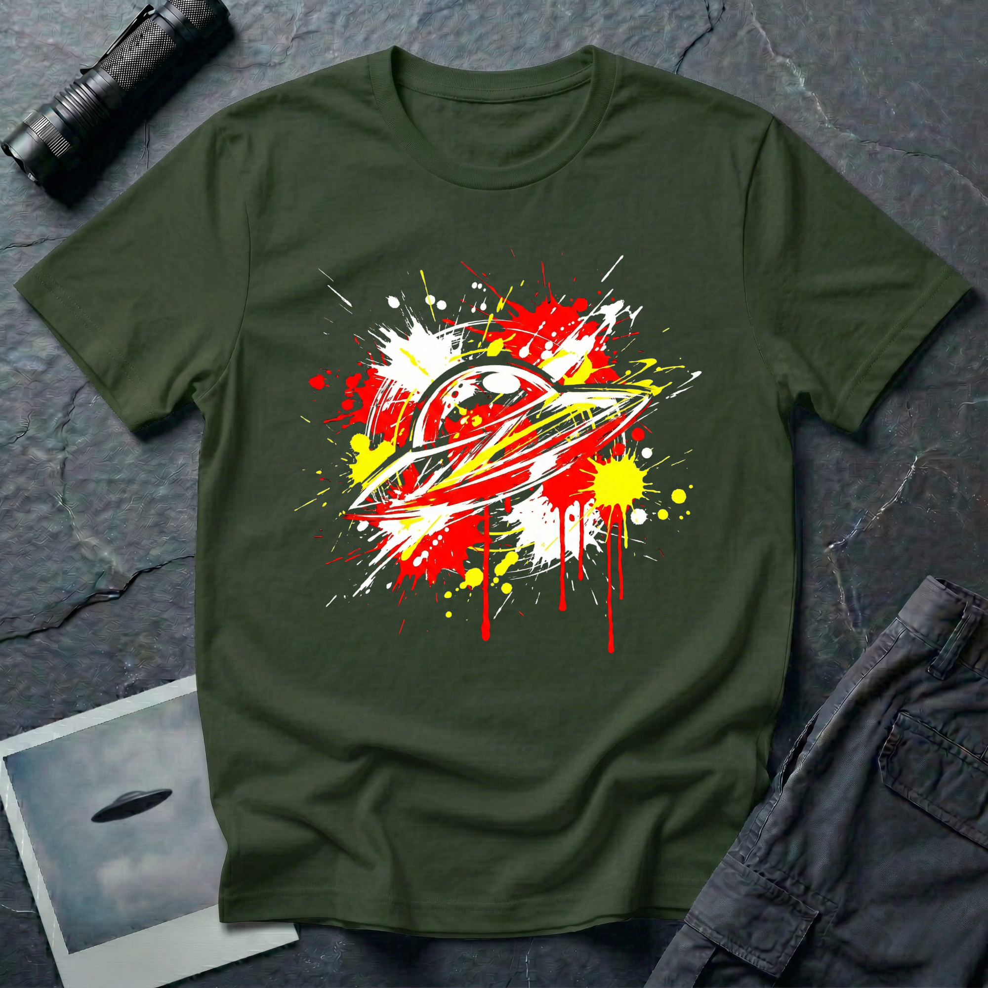 Crash Landing street art UFO t-shirt — flying saucer in explosive red, yellow, and white paint splatter with drips on green cotton tee