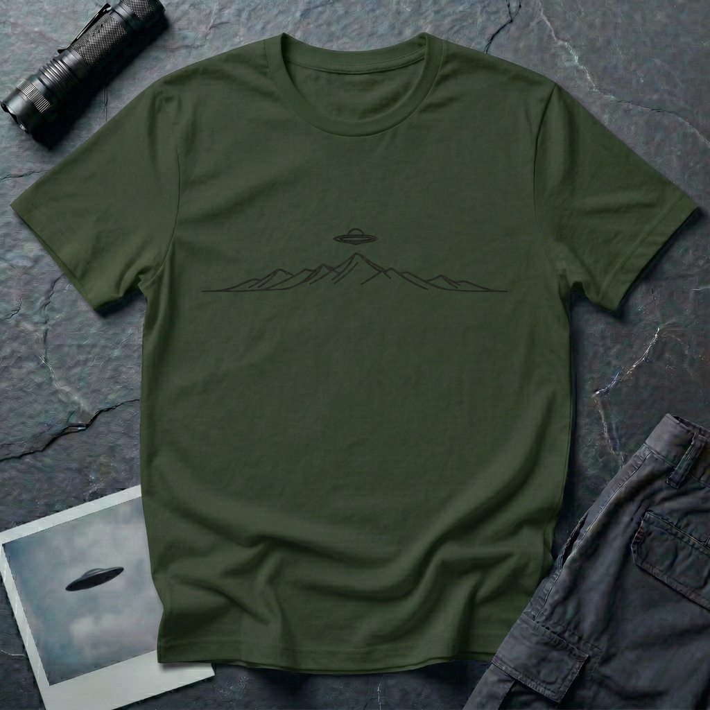 Line Drawing UFO minimalist mountain t-shirt — fine black linework mountain range with small flying saucer above the central peak on green cotton tee