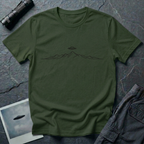 Line Drawing UFO minimalist mountain t-shirt — fine black linework mountain range with small flying saucer above the central peak on green cotton tee