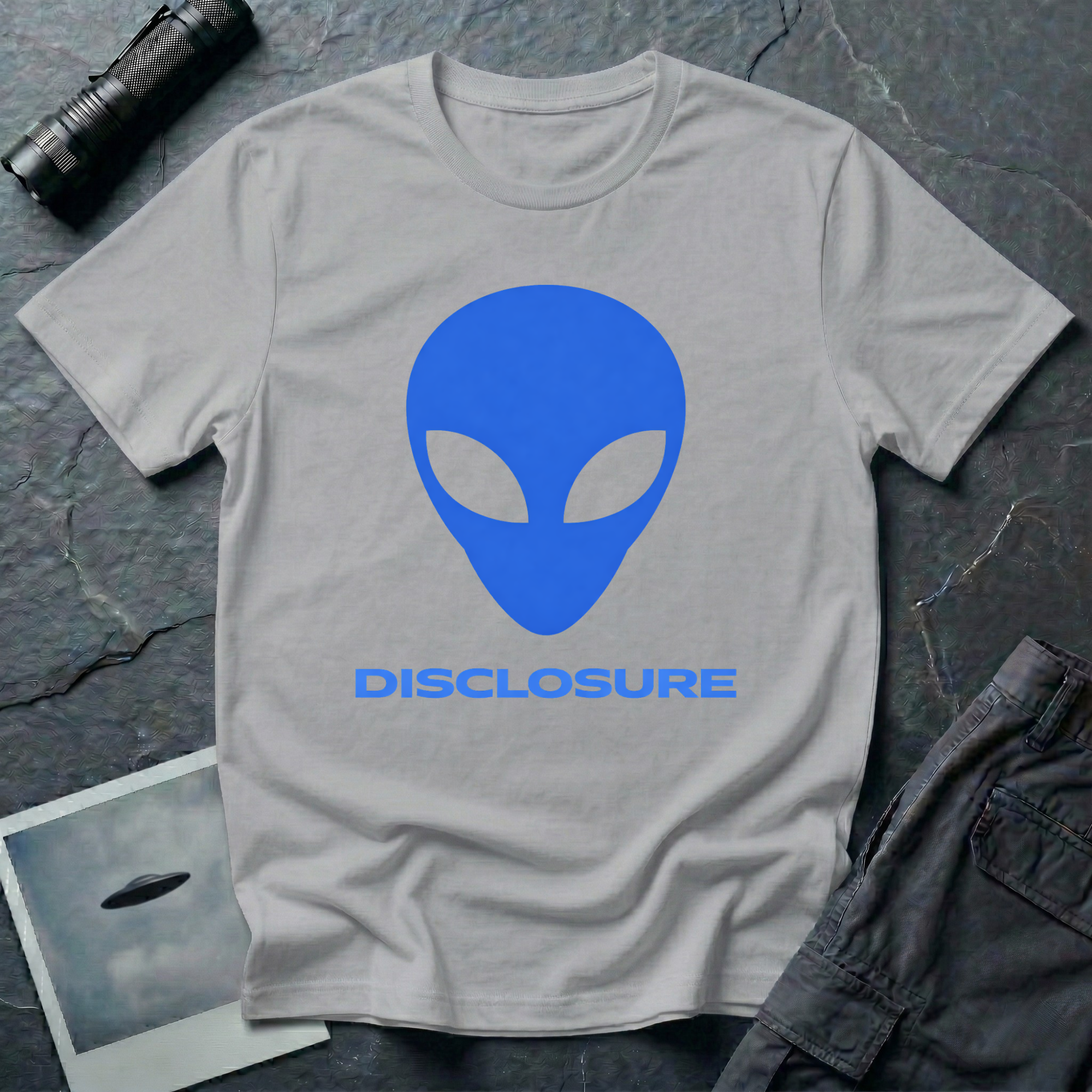 Alien Disclosure grey alien t-shirt — classic bulbous-head alien with almond eyes in electric blue on grey unisex cotton tee
