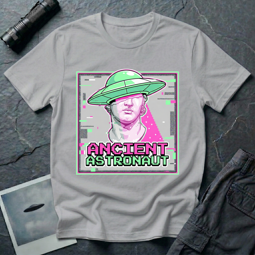 Ancient Astronaut vaporwave UFO t-shirt — classical Greek Roman marble bust statue in pink and purple with bright green flying saucer on head, digital glitch effects, gray distortion bars, and pixelated "ANCIENT ASTRONAUT" text in magenta and green on grey cotton tee