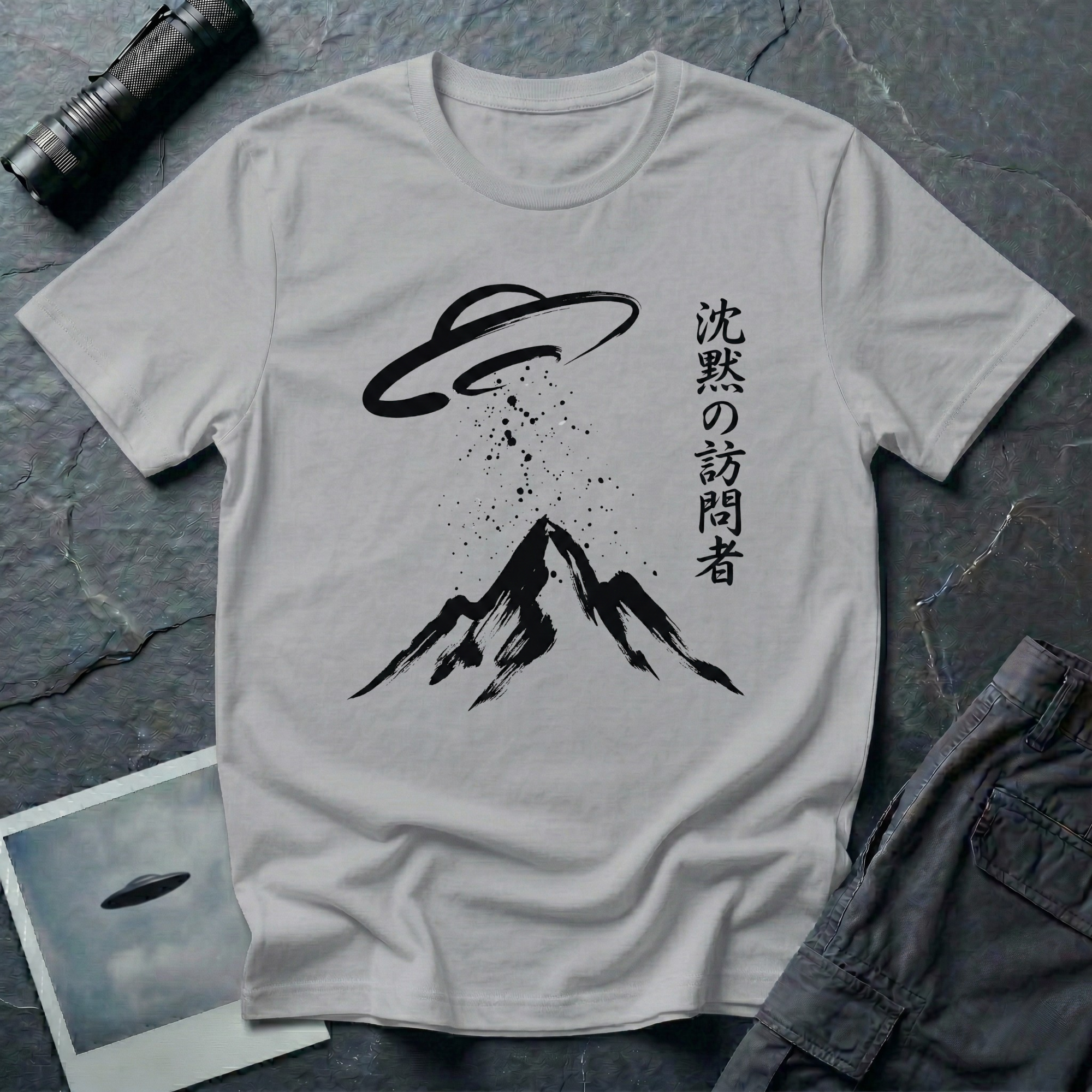 The Silent Visitor sumi-e UFO t-shirt — brush-painted flying saucer over mountain peak with Japanese "silent visitor" calligraphy on grey cotton tee