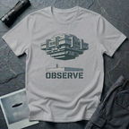 Observe Brutalist UFO t-shirt — massive concrete architectural craft hovering over small figure on plinth with "Observe" stencil type on grey cotton tee