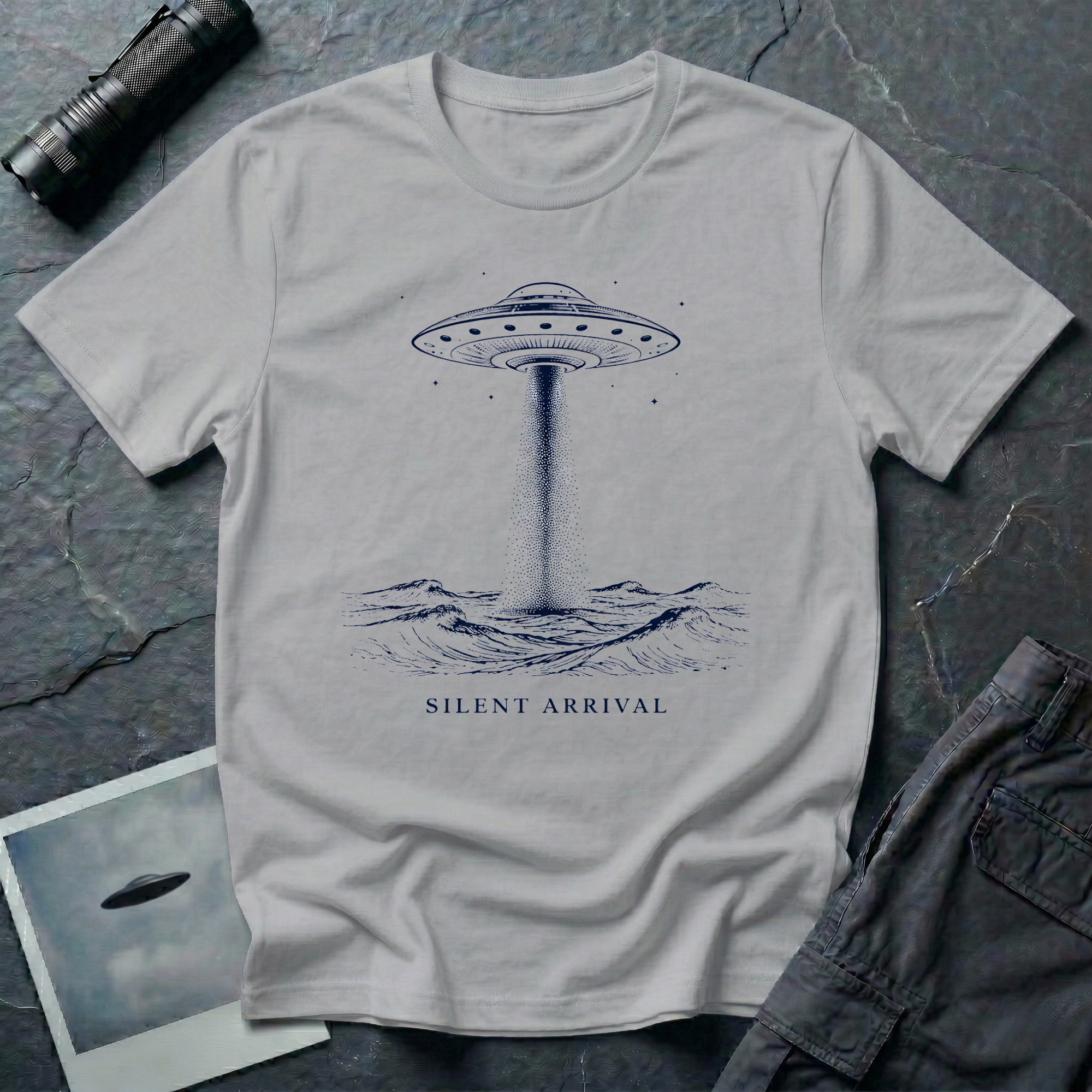 Silent Arrival ocean UFO t-shirt — flying saucer hovering over ocean waves with light beam on grey unisex cotton tee

