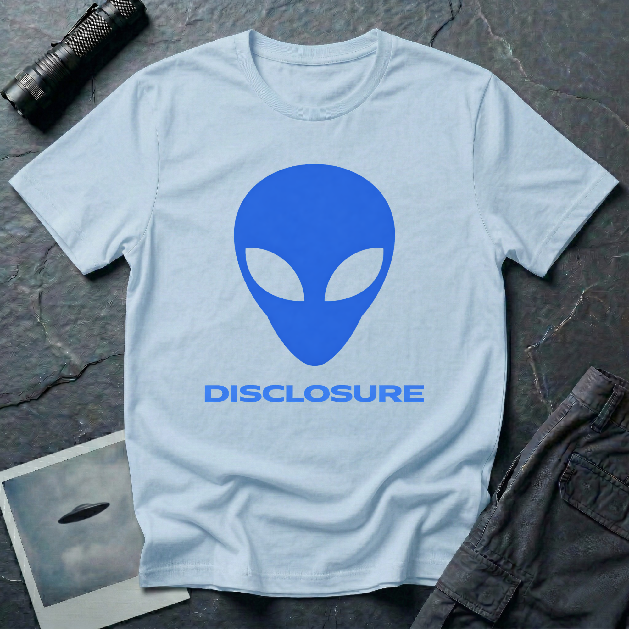 Alien Disclosure grey alien t-shirt — classic bulbous-head alien with almond eyes in electric blue on light blue unisex cotton tee
