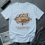 Extraterrestrial Apparatus steampunk UFO t-shirt — Victorian-era airship with exposed brass machinery gears and copper piping with "Extraterrestrial Apparatus 1888" caption on light blue cotton tee