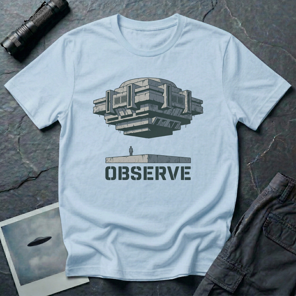 Observe Brutalist UFO t-shirt — massive concrete architectural craft hovering over small figure on plinth with "Observe" stencil type on pale blue cotton tee