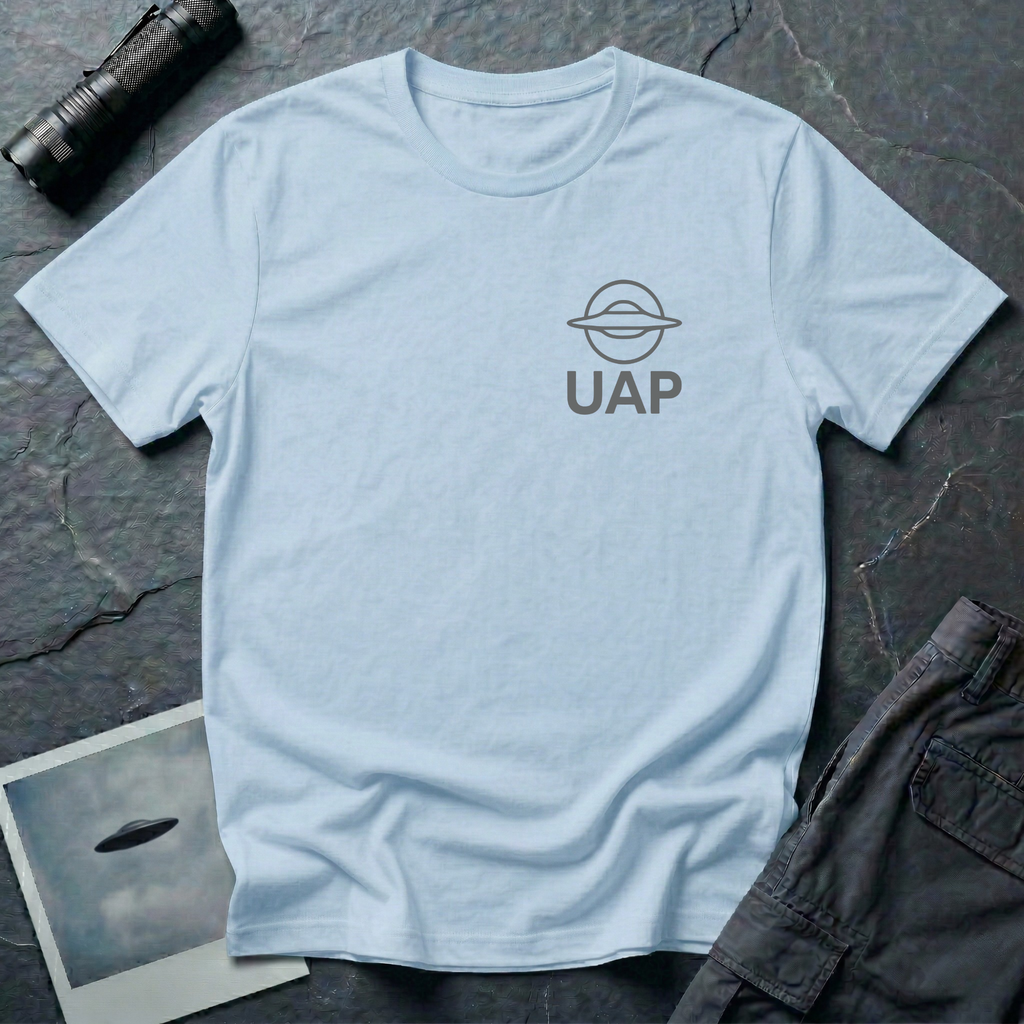 UAP logo t-shirt — small minimalist saucer icon and UAP letters in grey on the upper left chest of light blue cotton tee