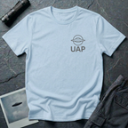 UAP logo t-shirt — small minimalist saucer icon and UAP letters in grey on the upper left chest of light blue cotton tee