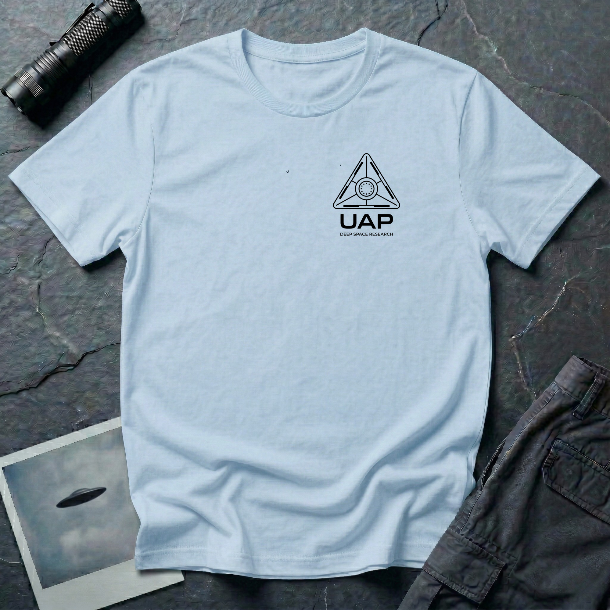 Light blue t-shirt with small left-chest black line art geometric triangle UAP mission patch design with the text UAP DEEP SPACE RESEARCH