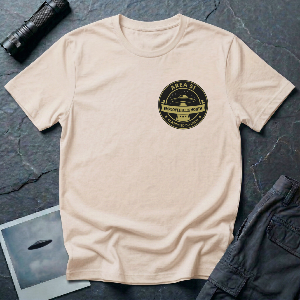 Area 51 Employee Of The Month UFO t-shirt — vintage circular badge with classic flying saucer, "Area 51" and "Classified Division" arc text, "Employee of the Month" ribbon banner in olive and black on upper-left chest of natural cotton tee