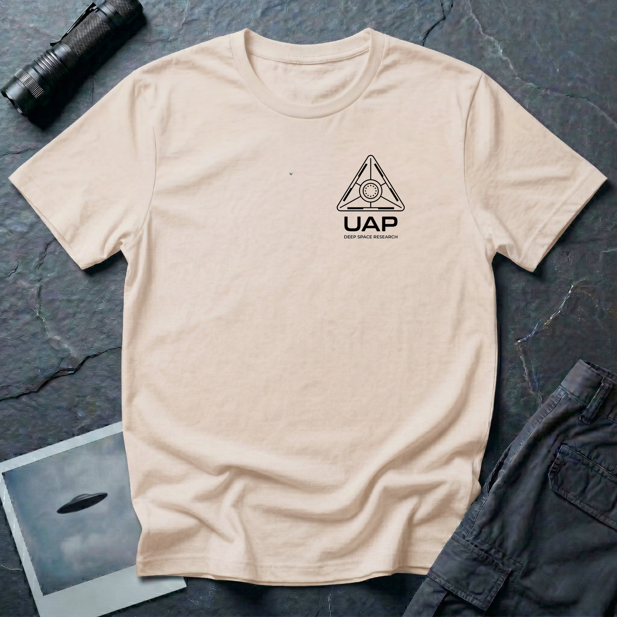 Natural t-shirt with small left-chest black line art geometric triangle UAP mission patch design with the text UAP DEEP SPACE RESEARCH