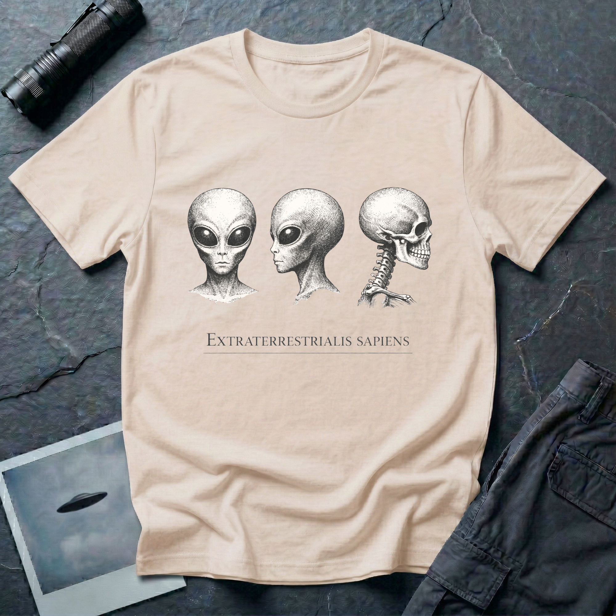 Extraterrestrialis Sapiens ancient aliens t-shirt — three heads in 19th-century anatomical study style with grey alien front and profile views and human skull on natural cotton tee