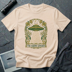 The Cosmic Garden Art Nouveau UFO t-shirt — ornate Mucha-style frame with flying saucer and botanical beam in green and gold on natural cotton tee