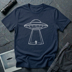 One Line UFO minimalist line art t-shirt — hand-drawn flying saucer beaming down over a tiny stick figure in one continuous white line on navy cotton tee