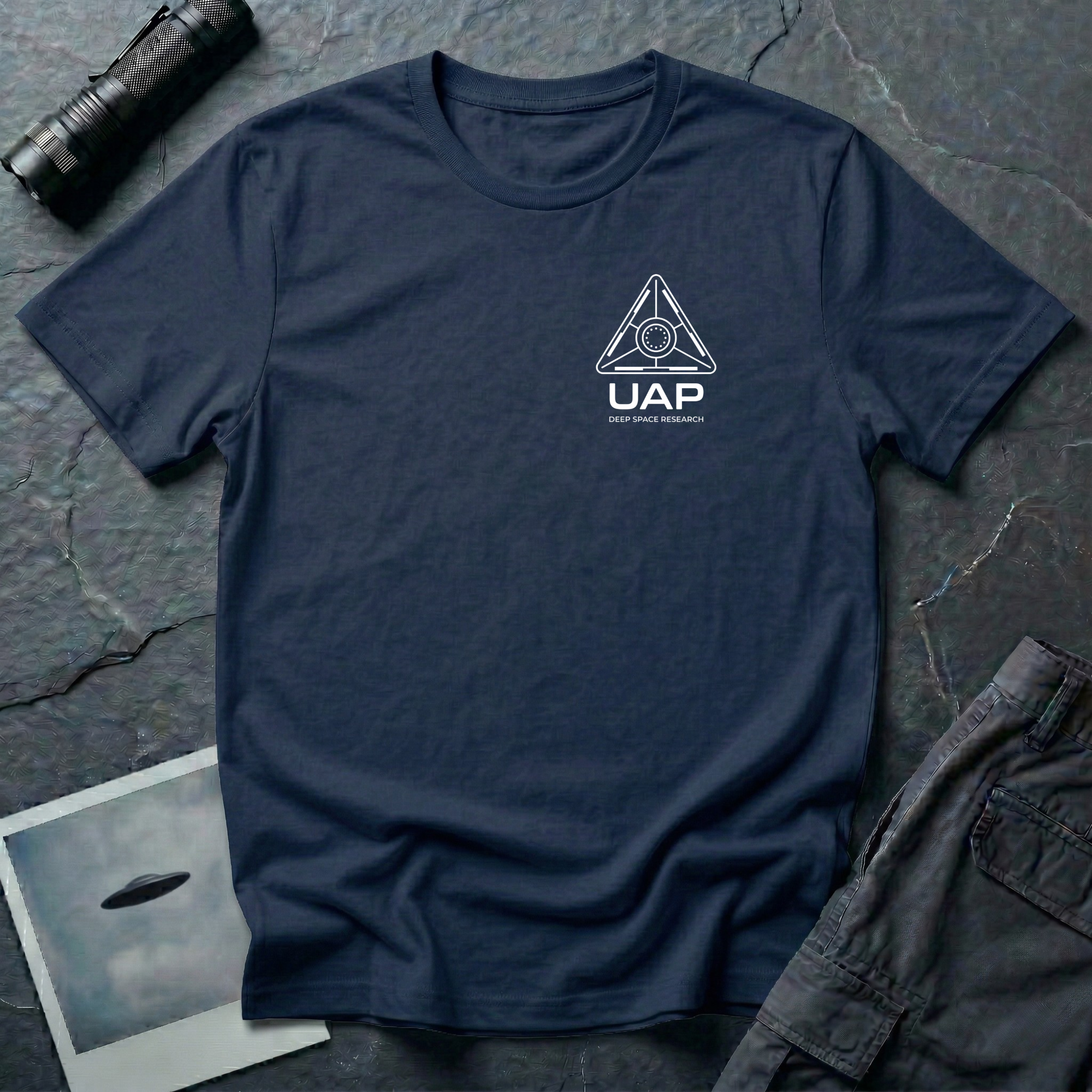 Navy blue t-shirt with small left-chest white line art geometric triangle UAP mission patch design with the text UAP DEEP SPACE RESEARCH