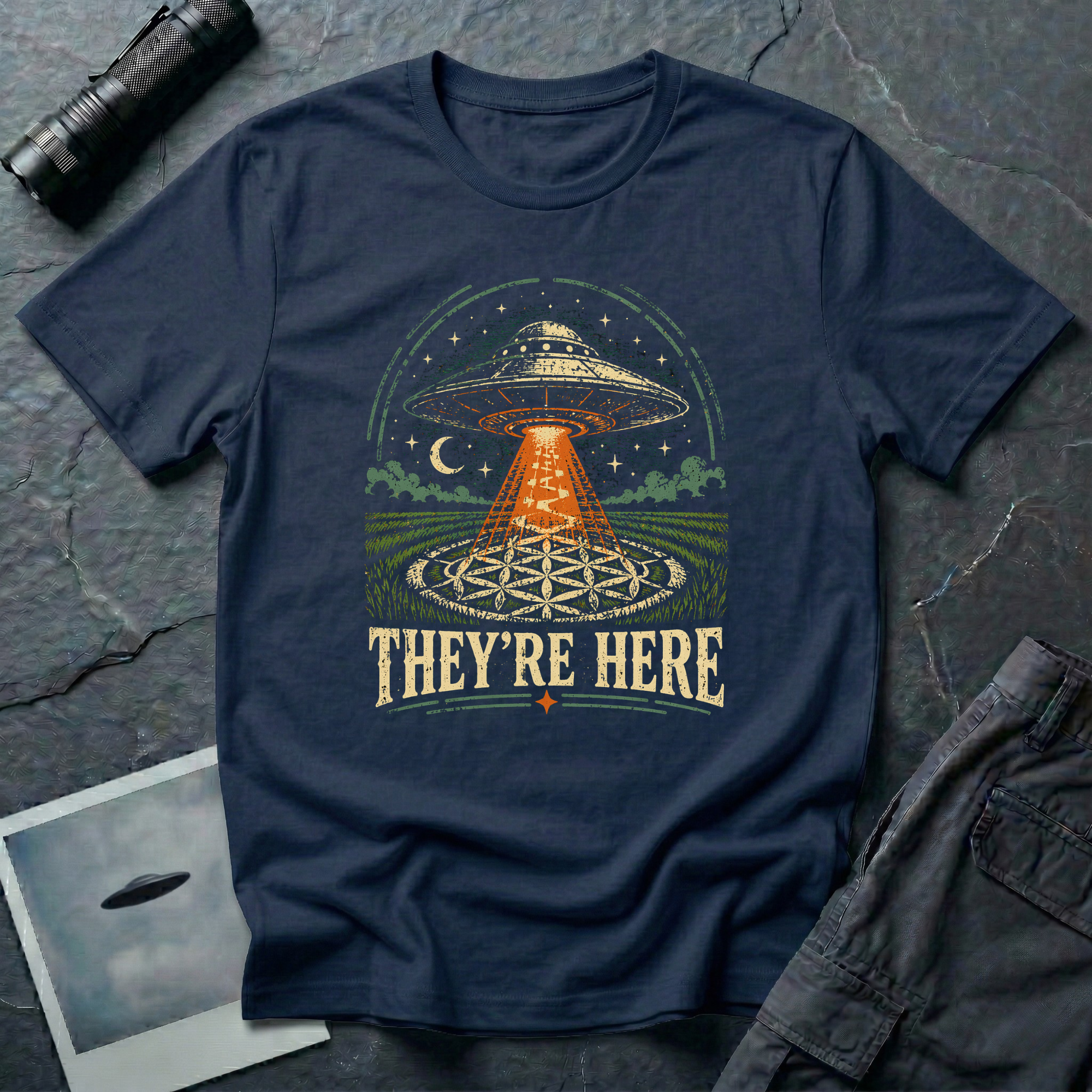 They're Here crop circle UFO t-shirt — flying saucer beaming over Flower of Life crop formation on navy unisex cotton tee