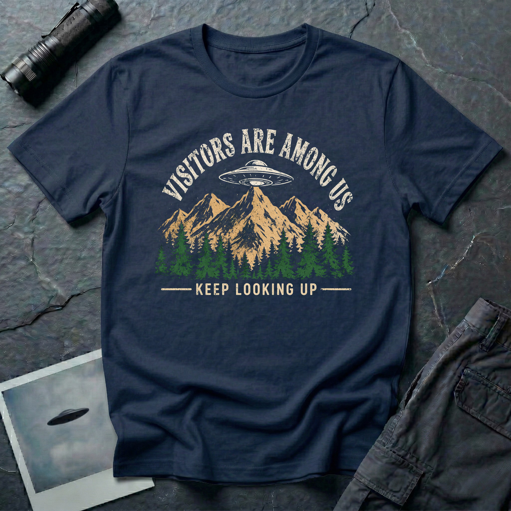 Visitors Are Among Us outdoor UFO t-shirt — flying saucer over mountain range and pine forest on navy unisex cotton tee
