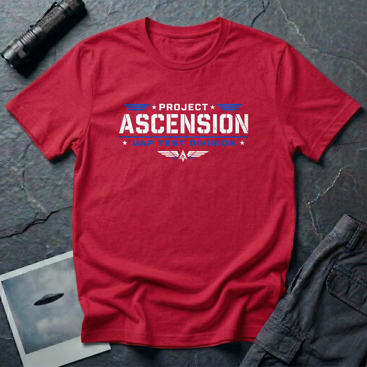 Red t-shirt with PROJECT ASCENSION UAP TEST DIVISION military stencil lettering in white and blue with winged delta emblem
