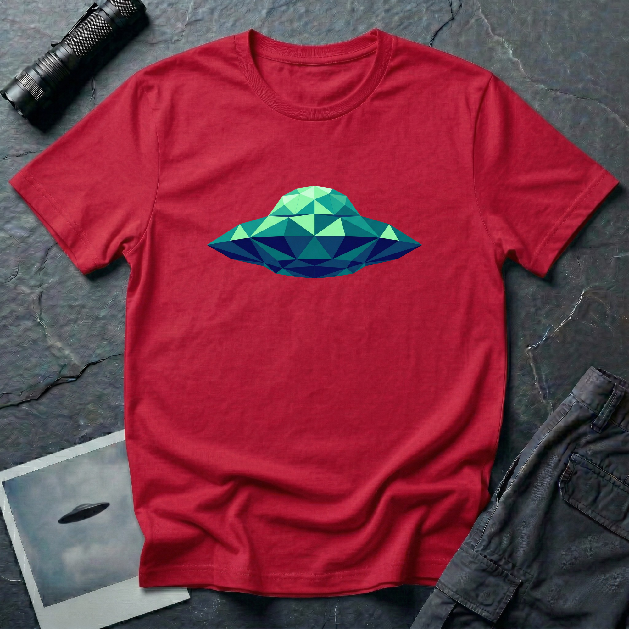 Cubist UFO geometric low poly t-shirt — classic flying saucer rendered in triangular facets of mint green, teal, and navy blue on red cotton tee
