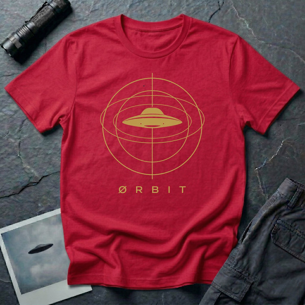 Orbit astronomical UFO t-shirt — flying saucer centred in a gold orbital sphere framework with "Ørbit" sans serif typography on red cotton tee