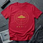 Orbit astronomical UFO t-shirt — flying saucer centred in a gold orbital sphere framework with "Ørbit" sans serif typography on red cotton tee