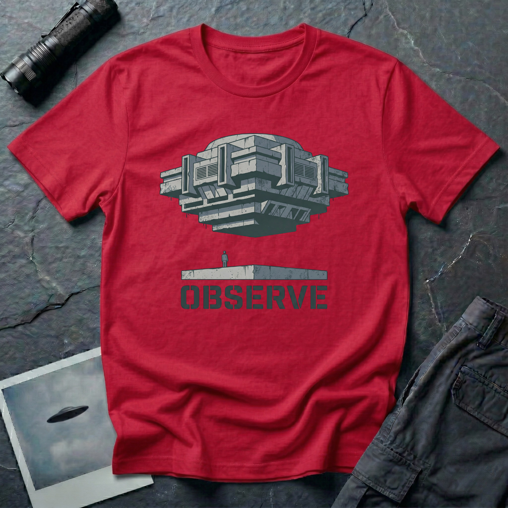 Observe Brutalist UFO t-shirt — massive concrete architectural craft hovering over small figure on plinth with "Observe" stencil type on red cotton tee