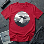 Papercut UFO t-shirt — layered paper-craft illustration of flying saucer over mountains and clouds in grey monochrome on red cotton tee