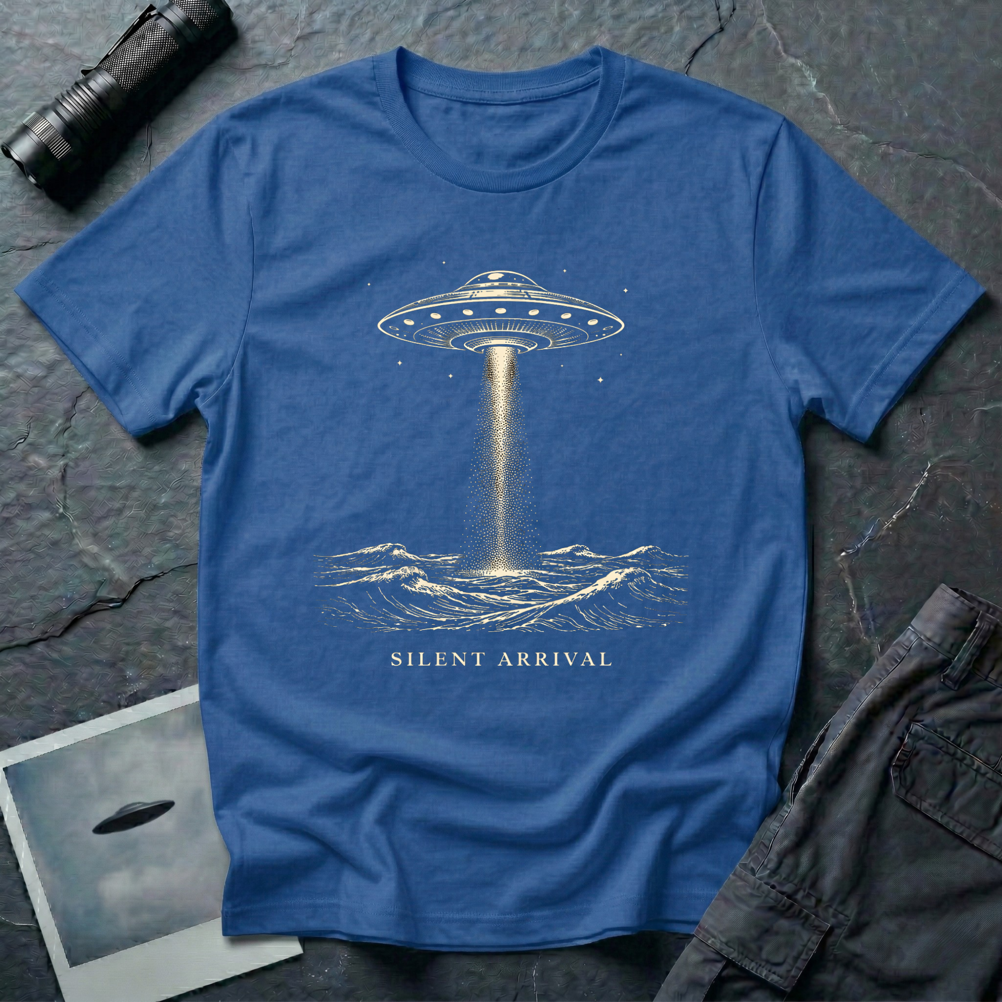 Silent Arrival ocean UFO t-shirt — flying saucer hovering over ocean waves with light beam on blue unisex cotton tee
