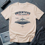 Natural t-shirt with military-style UAP Reverse Engineering Division patch featuring an annotated saucer diagram with gravitational flux core anti-inertia ring and plasma propulsion vents callouts