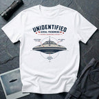 White t-shirt with military-style UAP Reverse Engineering Division patch featuring an annotated saucer diagram with gravitational flux core anti-inertia ring and plasma propulsion vents callouts