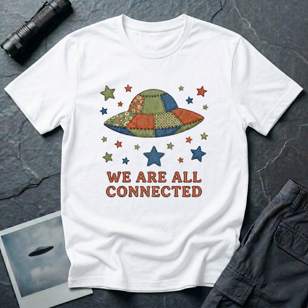 We Are All Connected folk quilt UFO t-shirt — patchwork saucer with cross-stitched fabric panels and stars in rust, navy and olive on white cotton tee