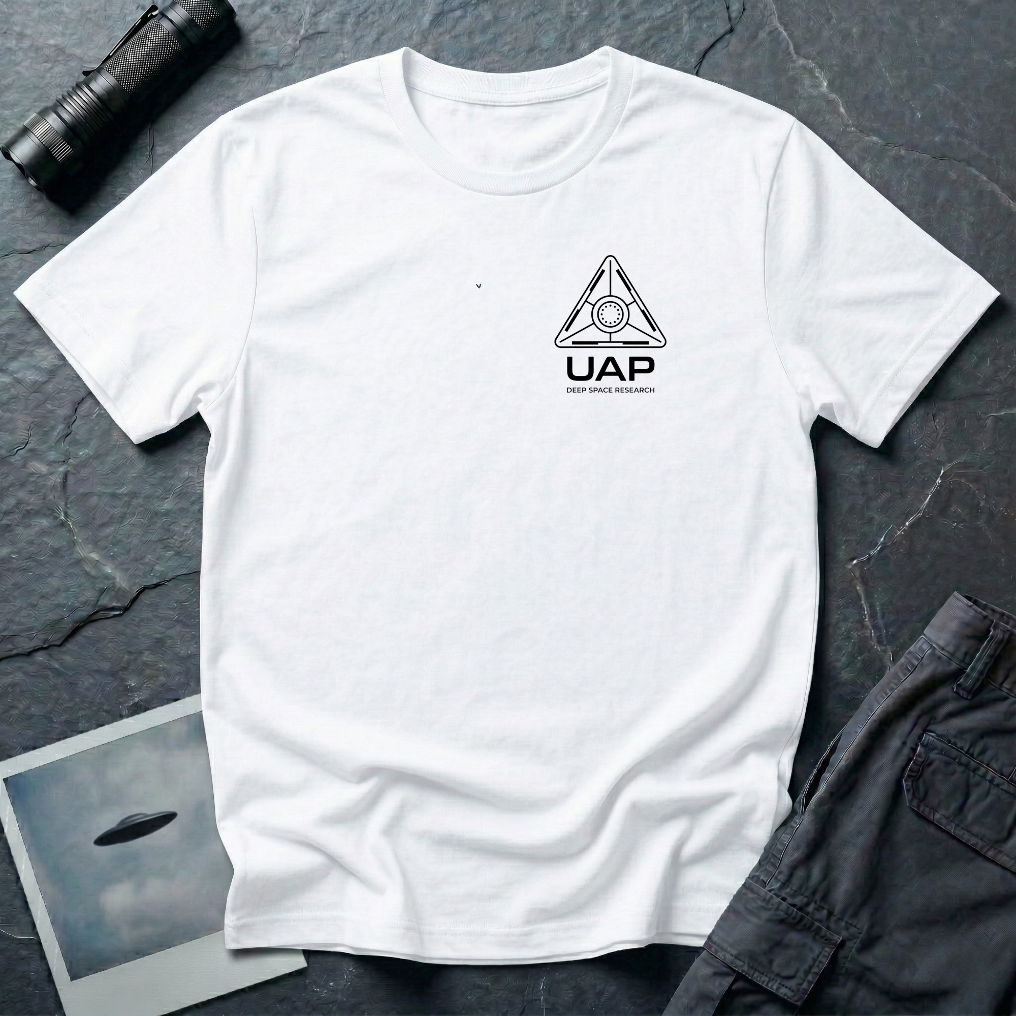 White t-shirt with small left-chest black line art geometric triangle UAP mission patch design with the text UAP DEEP SPACE RESEARCH