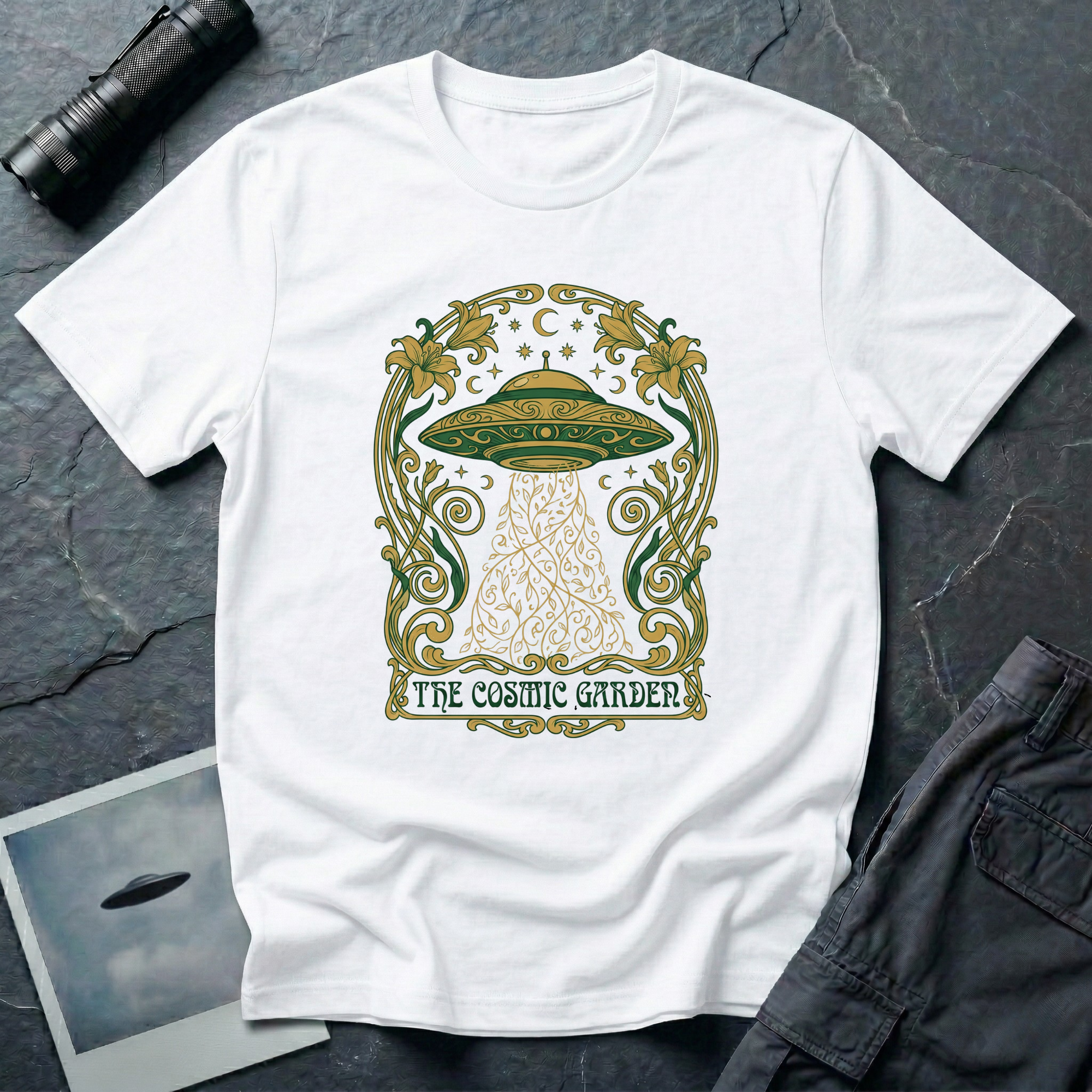 The Cosmic Garden Art Nouveau UFO t-shirt — ornate Mucha-style frame with flying saucer and botanical beam in green and gold on white cotton tee