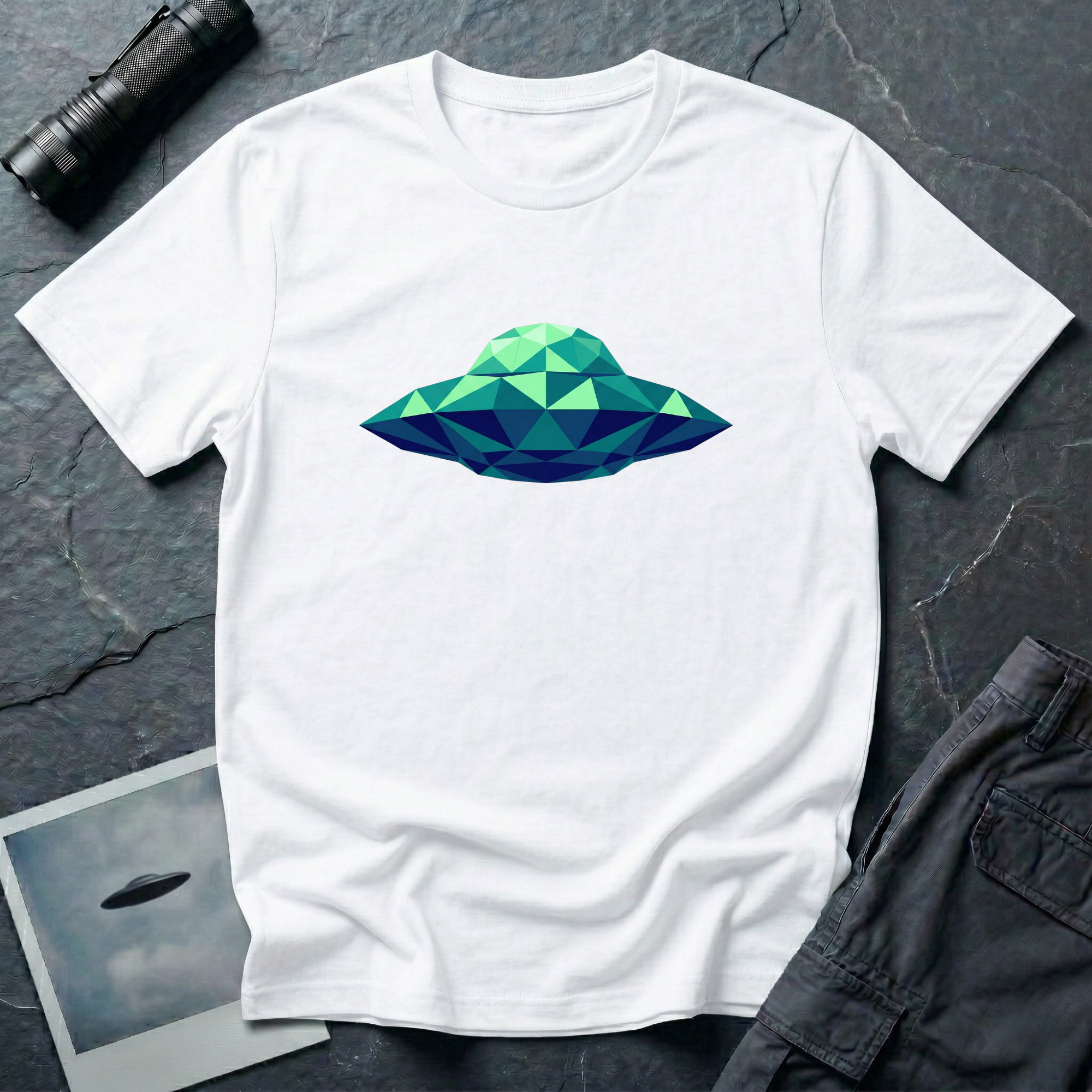 Cubist UFO geometric low poly t-shirt — classic flying saucer rendered in triangular facets of mint green, teal, and navy blue on white cotton tee