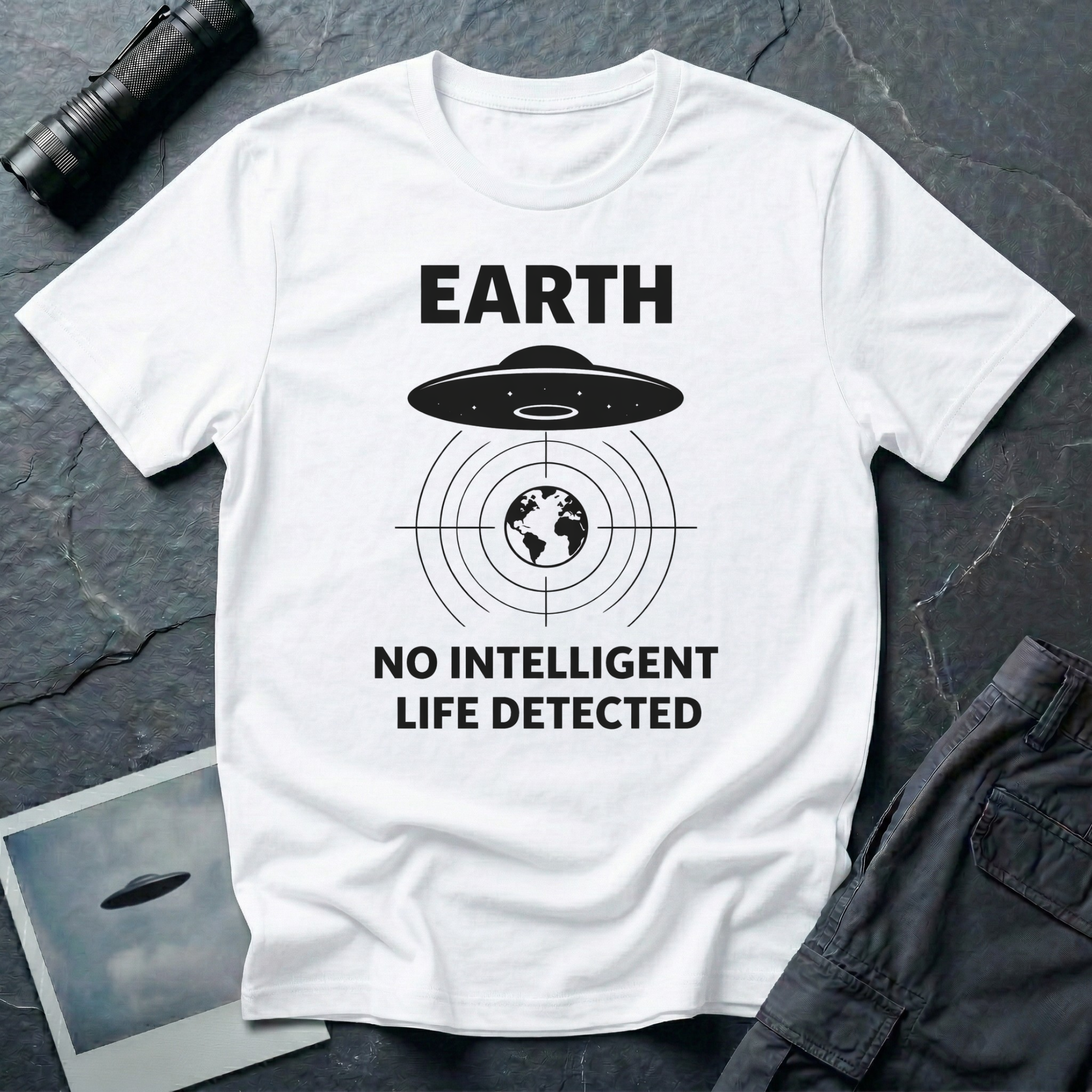 No Intelligent Life Detected UFO t-shirt — classic flying saucer above concentric scan rings and crosshairs targeting Earth with "EARTH / NO INTELLIGENT LIFE DETECTED" caption in black on white cotton tee