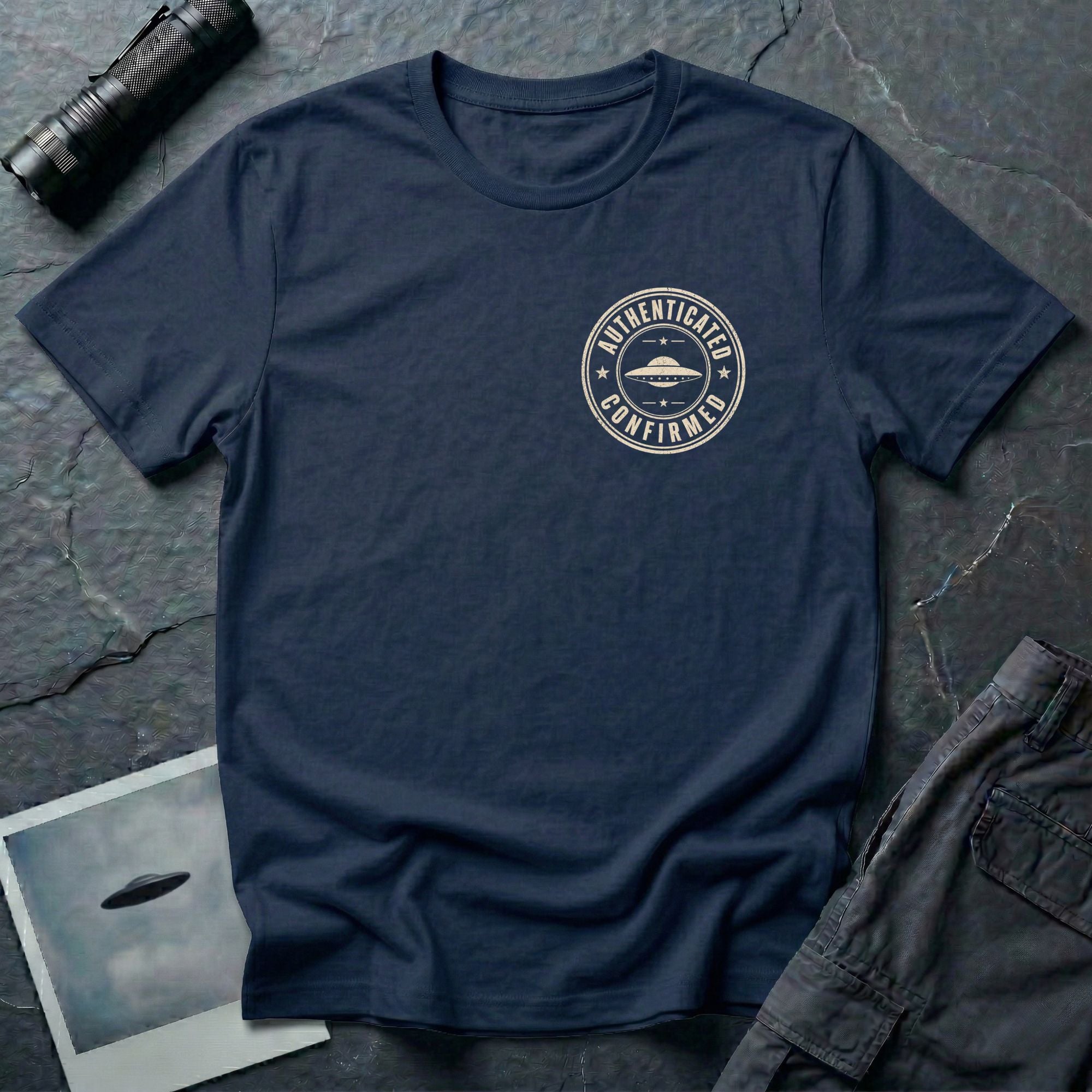 Navy blue UFO t-shirt with a small distressed circular badge on the left chest showing a flying saucer and the words AUTHENTICATED CONFIRMED in cream white