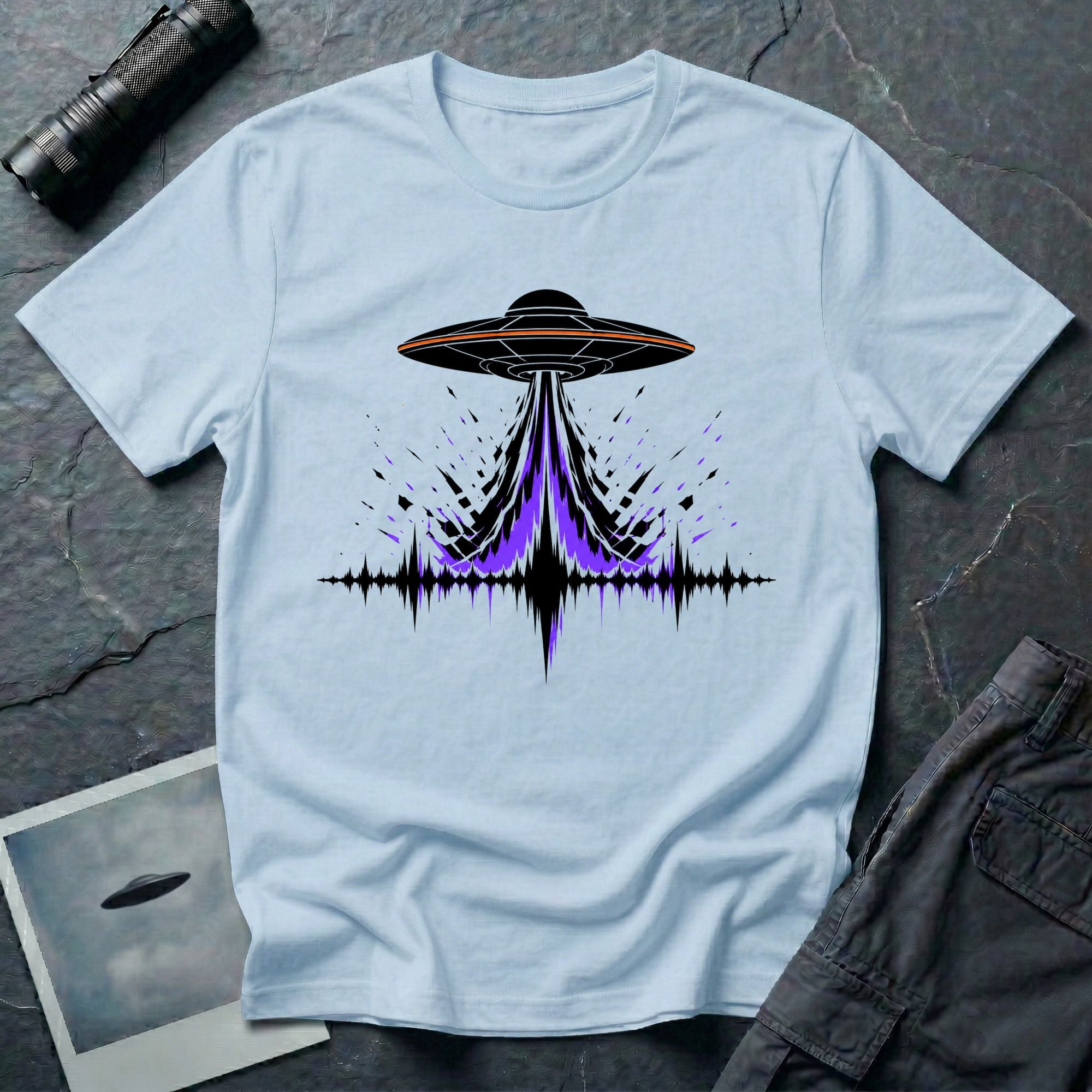 Carrier Wave UFO graphic t-shirt with black saucer emitting a purple and black audio frequency waveform, light blue