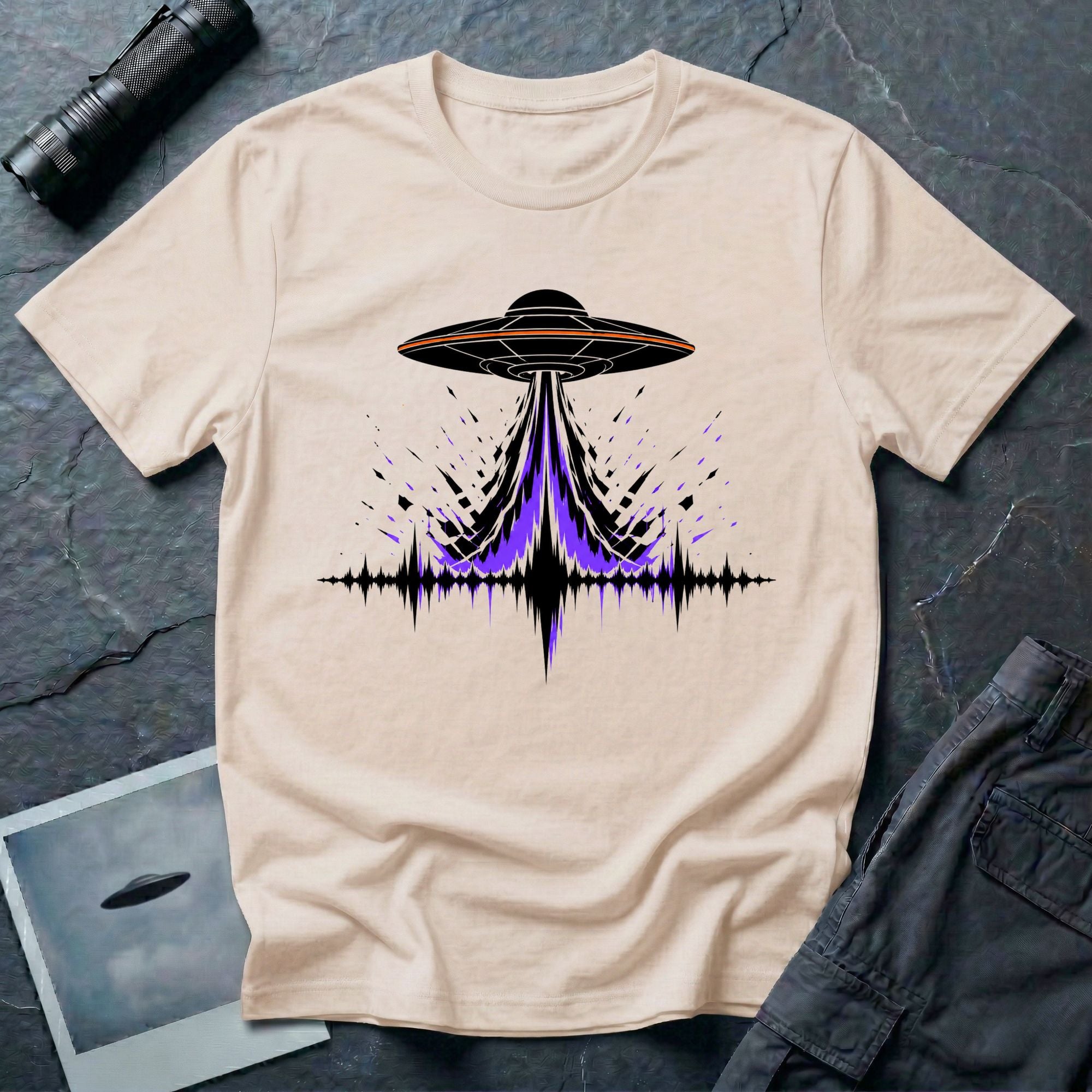 Carrier Wave UFO graphic t-shirt with black saucer emitting a purple and black audio frequency waveform, natural