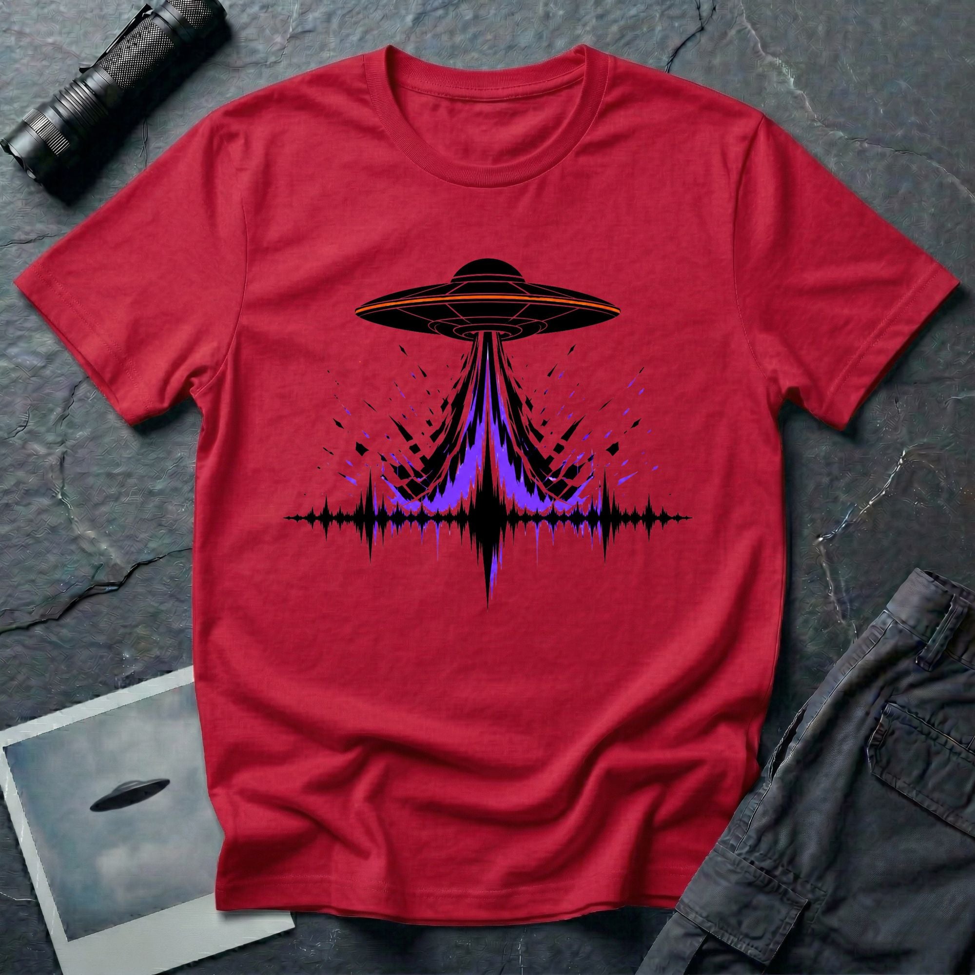 Carrier Wave UFO graphic t-shirt with black saucer emitting a purple and black audio frequency waveform, red