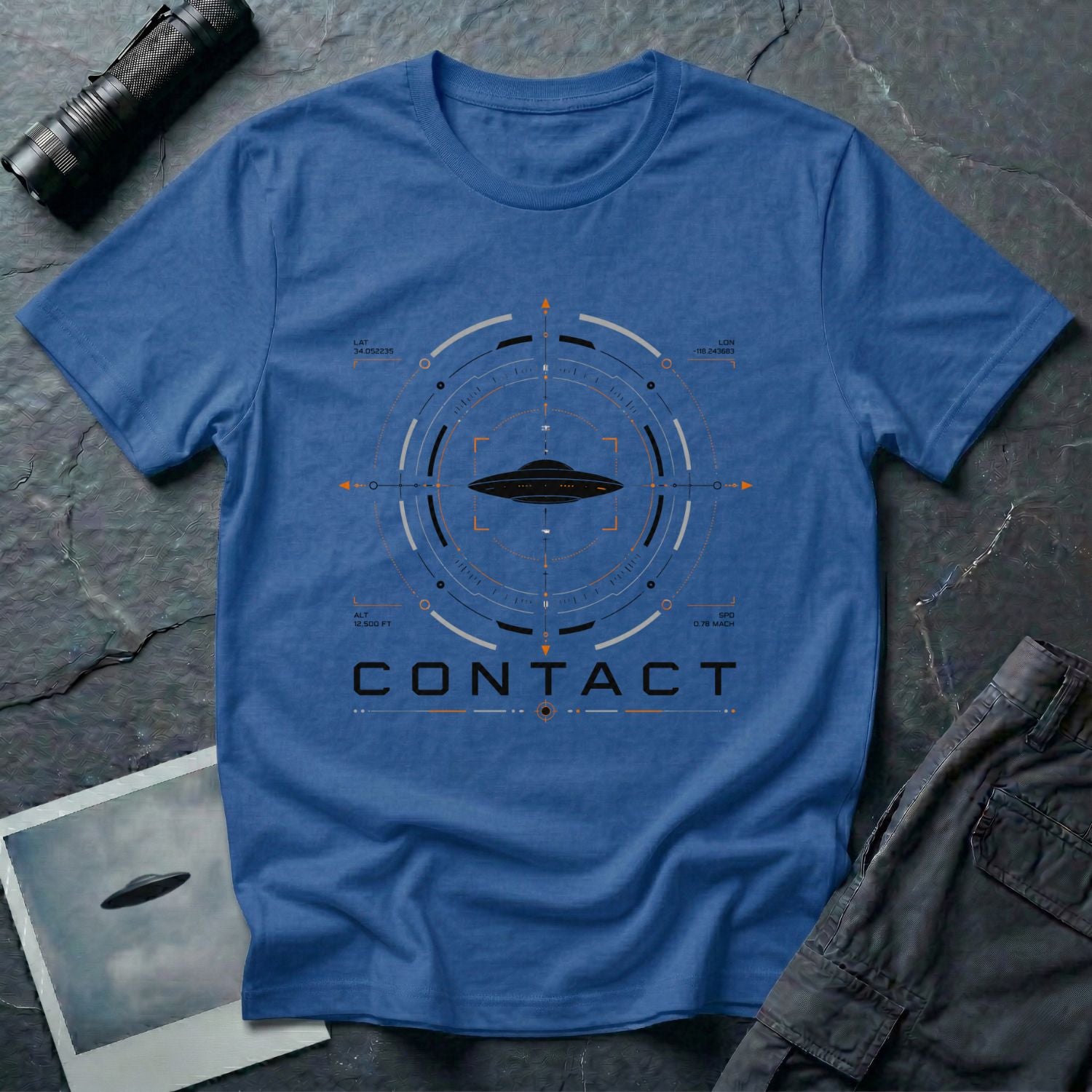 Royal blue UAP t-shirt with a flying saucer inside a military radar targeting interface showing Los Angeles coordinates, altitude, and speed data with the word CONTACT