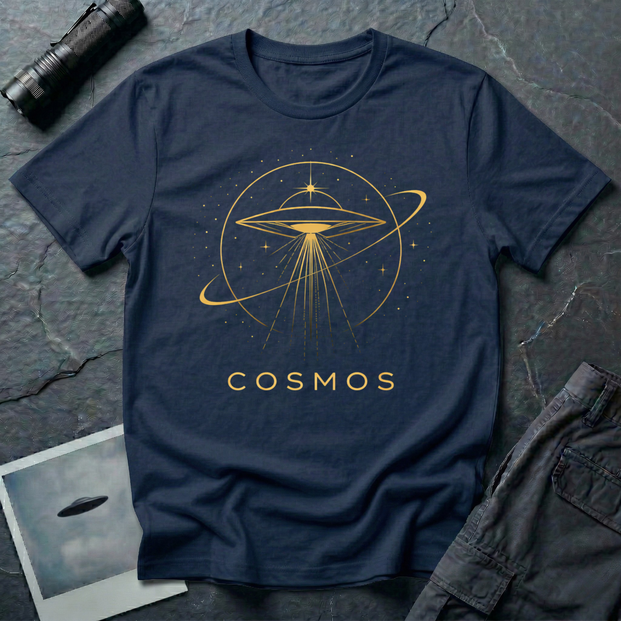 Cosmos cosmic UFO t-shirt — gold line-drawn flying saucer inside orbital planetary rings on navy unisex cotton tee