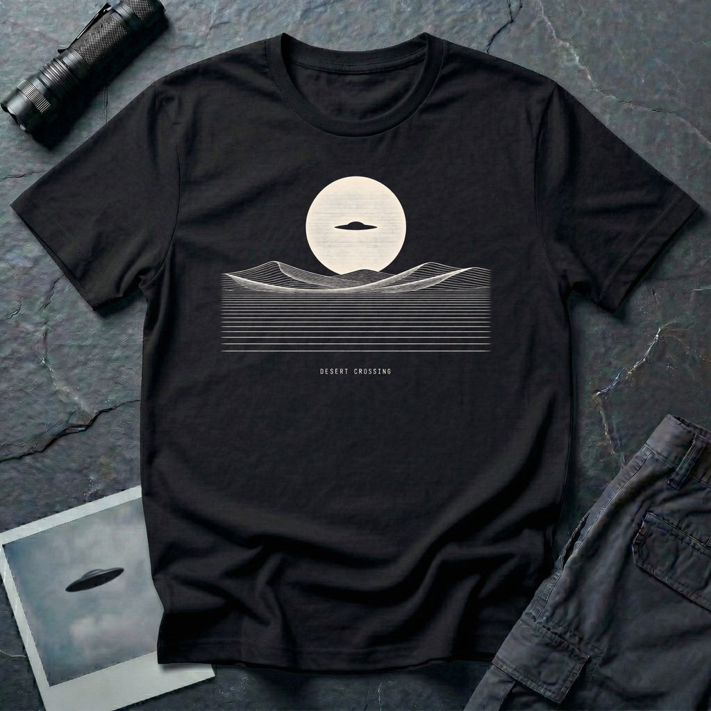 Desert Crossing UFO T-shirt with a black flying saucer crossing a white moon above minimalist line-art desert dunes, black tee