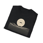 Desert Crossing UFO T-shirt with a black flying saucer crossing a white moon above minimalist line-art desert dunes, black tee